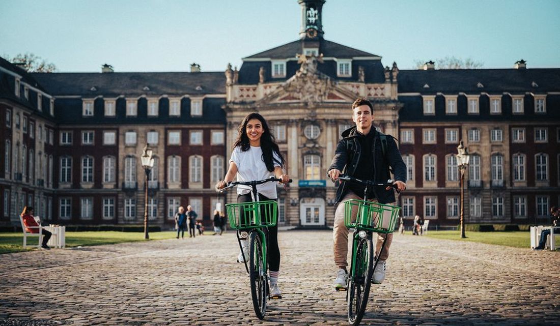 Estudiantes en bicicleta yendo a la universidad